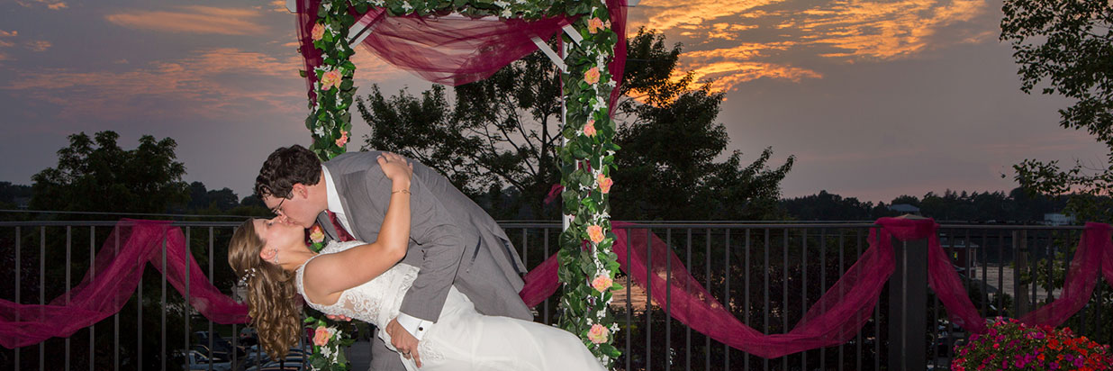 bride and groom kissing on the terrace at sunset